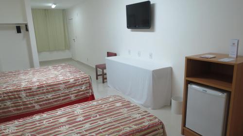 a hotel room with a bed and a television at Atlântico Centro Apartments in Rio de Janeiro