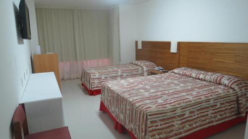 מיטה או מיטות בחדר ב-Atlântico Centro Apartments