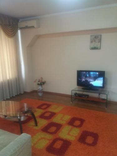 a living room with a couch and a flat screen tv at Квартира in Almaty