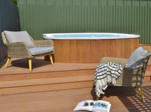 a hot tub sitting on a deck with two chairs at Hotel De Diane in Sables-dʼOr-les-Pins