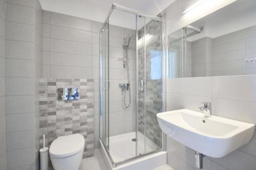 a bathroom with a shower and a sink and a toilet at Xanadu Resort in Sianozety