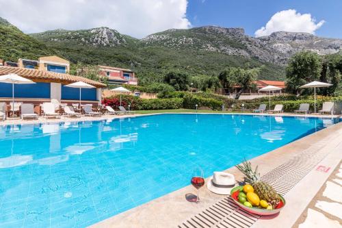 a pool at a resort with a bowl of fruit at Akti Barbati Houses by Konnect in Barbati