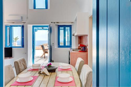 a dining room with a table and chairs and a kitchen at Desiterra Resort & Spa in Fira