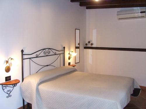 1 dormitorio con 1 cama blanca en una habitación en Casa Martineriu, en Orosei