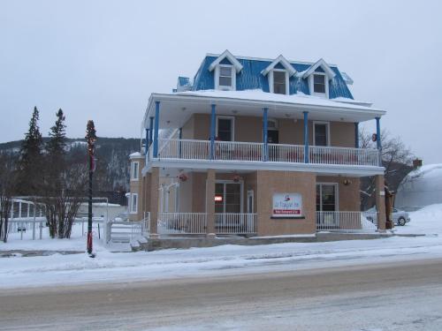 a large house with a blue roof on a street at Le Voyageur Inn in Mattawa