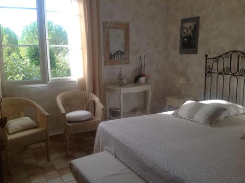 アルトン・デ・パリュにあるMas de la Graveのベッドルーム1室(白いベッド1台、椅子2脚付)
