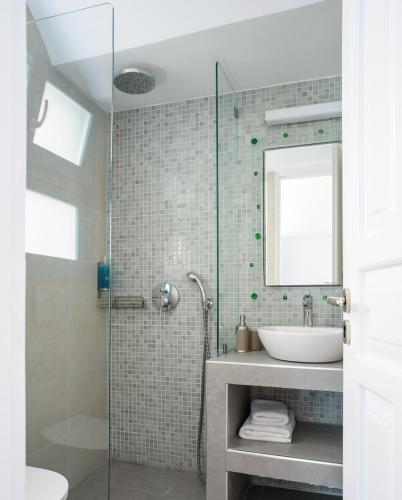 a bathroom with a sink and a glass shower at Nikolas Hotel in Karterados