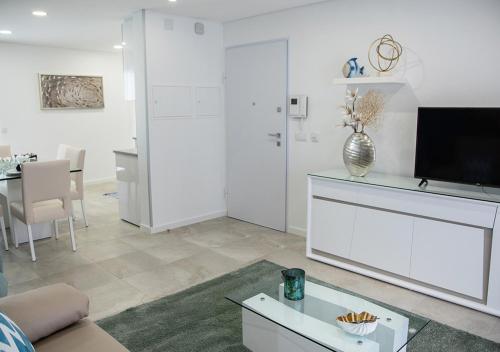 a living room with a couch and a tv at Real Holidays Nazaré in Nazaré