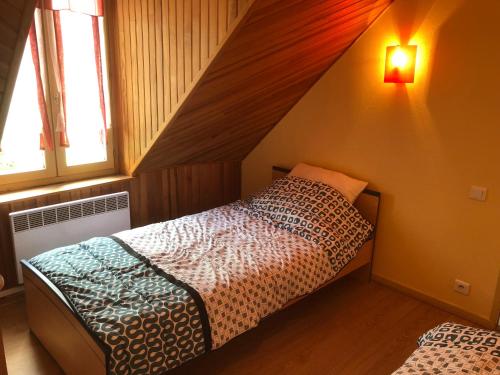 een slaapkamer met een bed in een zolderkamer bij Résidence Les Cascades in Le Mont-Dore