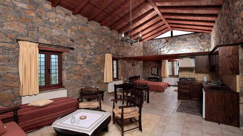 a large living room with a stone wall at Arodamos Guesthouse in Krousón