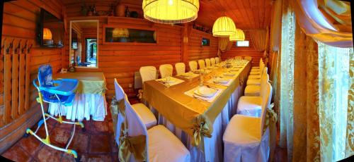 a dining room with a long table and chairs at Medzhybozhskiy Zamok in Tribukhovtsy