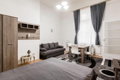ブダペストにあるW2 Synagogue Apartmentのベッドルーム1室(ベッド1台、テーブル、ソファ付)