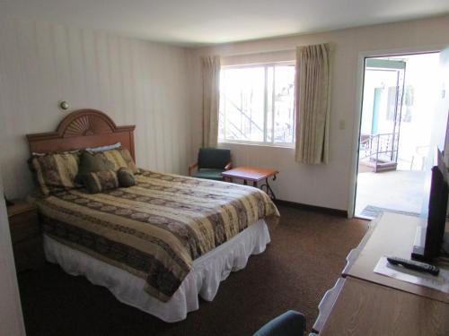 a hotel room with a bed and a balcony at The Lake George Inn in Lake George