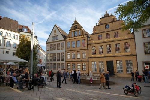 a group of people standing around in a street with buildings at LÉGÈRE EXPRESS Bielefeld in Bielefeld