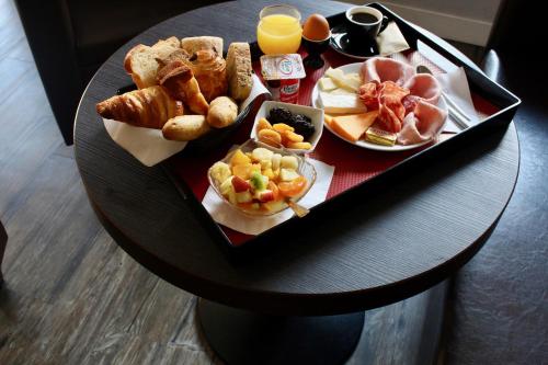 a tray of breakfast foods on a table at Logis Hotel - Le Charleston in Le Mans
