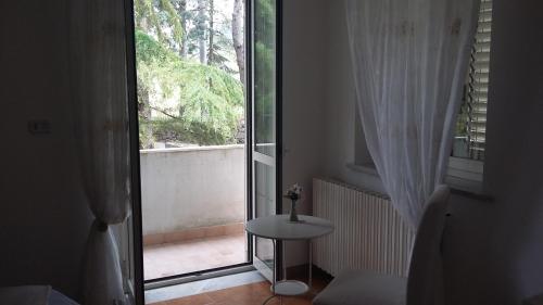 貝內文托的住宿－B&B Casa di Laura，一间设有一扇门的客房,可通往带桌子的阳台