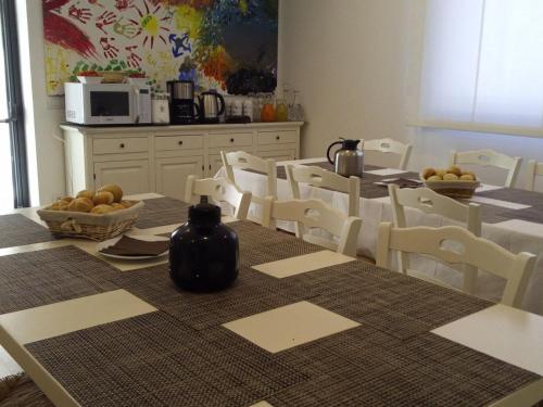 a dining room with a table and chairs and a kitchen at Agriturismo La Semente in Spello