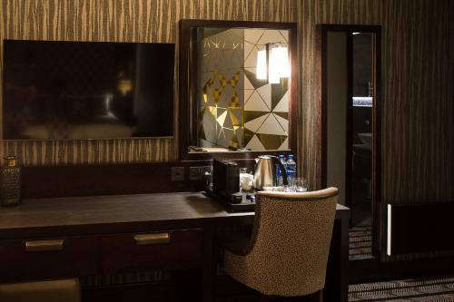 コートブリッジにあるMondo Hotelのデスク、椅子、鏡が備わる客室です。
