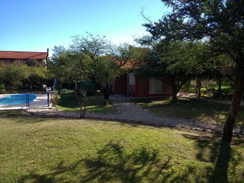 un patio con piscina y una casa en Cabañas Quinco en Merlo