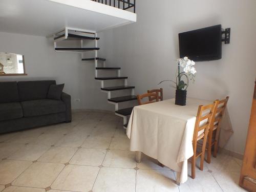 a living room with a table and a spiral staircase at Hotel Paganini in Nice