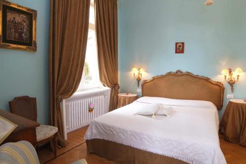 a bedroom with a bed with white sheets and a window at La Casa di Anny camere di Charme Citr 8027 in Diano Marina