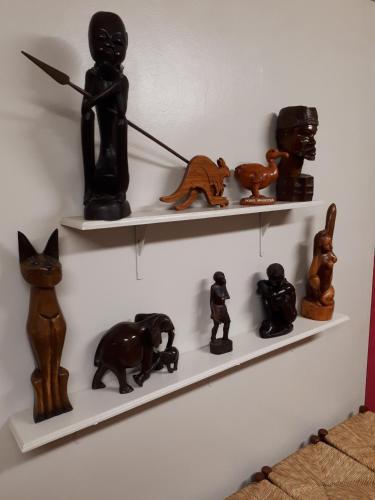 a shelf with various figurines on it on a wall at Les GREVILLEAS in La Plaine des Cafres