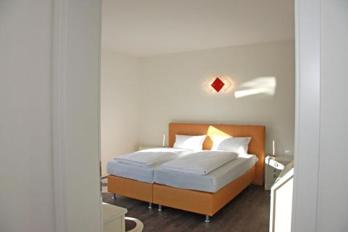 Kehrwieder No5 في هايليغنهافن: غرفة نوم بسرير ذو شراشف بيضاء ومخدات بيضاء