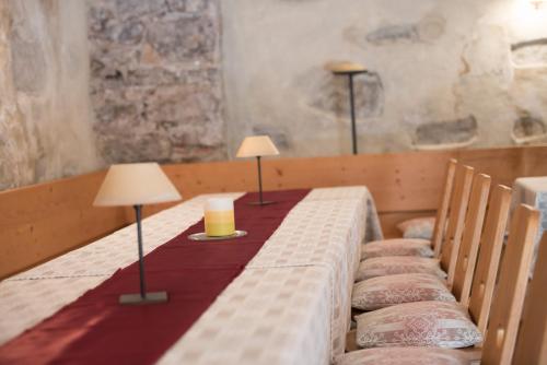 a table with two lamps and two candles on it at Ansitz Wendelstein in Appiano sulla Strada del Vino