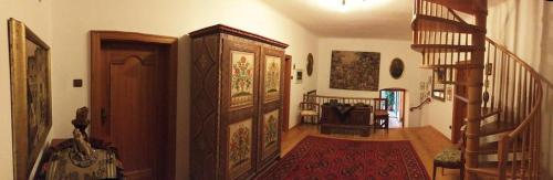 a living room with a staircase and a large wooden door at Ansitz Wendelstein in Appiano sulla Strada del Vino