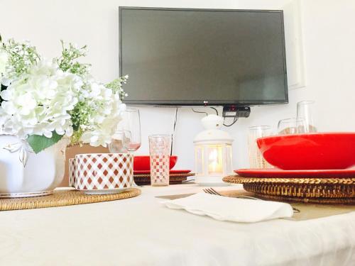 a dining room table with a flat screen tv at BS Villas Porto in Porto