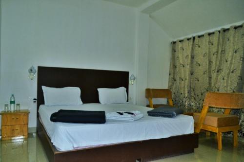 a bedroom with a large bed and a chair at Crossbill Beach Resort in Havelock Island