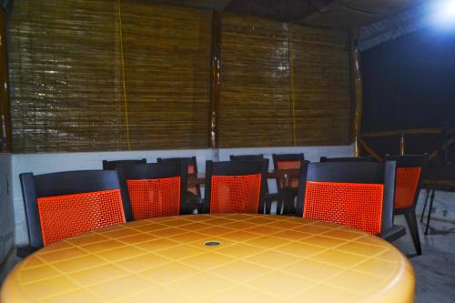a dining room with a yellow table and chairs at Crossbill Beach Resort in Havelock Island