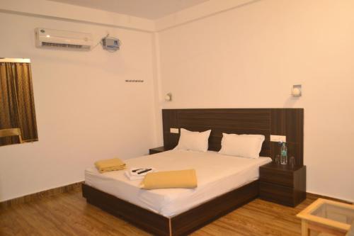 a bedroom with a large bed with white sheets at Crossbill Beach Resort in Havelock Island