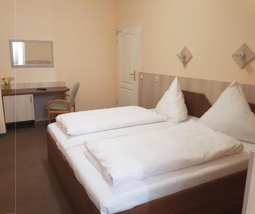 a bedroom with two beds with white sheets at Pension Im Bett in Nuremberg