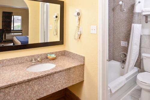 a bathroom with a sink and a toilet and a mirror at Americas Best Value Inn Medical Center Downtown in Houston