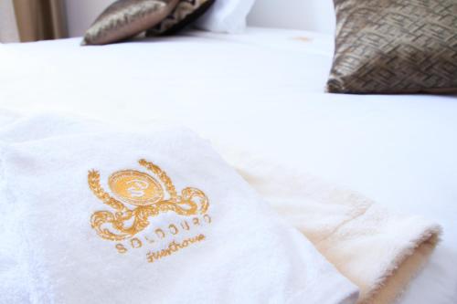 a white towel with an octopus on a bed at Soldouro Guesthouse in Aveiro
