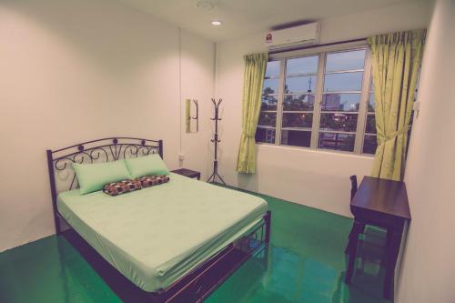 Schlafzimmer mit einem Bett und einem Fenster in der Unterkunft The Haven Inn in Malakka