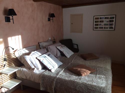 ein Schlafzimmer mit einem Bett mit Kissen darauf in der Unterkunft La Maison de Valentine in Jarjayes