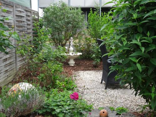 un jardín con un banco y algunas plantas y flores en Ferienwohnung im Grünen en Wolfurt