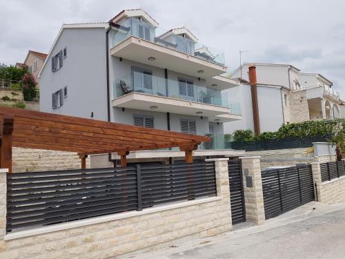 a wooden bench on a fence in front of a building at Villa Kozina in Podstrana