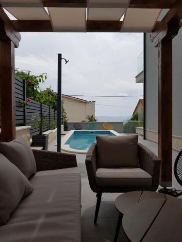 a living room with a couch and a swimming pool at Villa Kozina in Podstrana