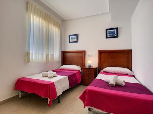 マール・デ・クリスタルにあるRibera Beach 3 - 0809の赤と白のシーツが備わるベッドルームのベッド2台