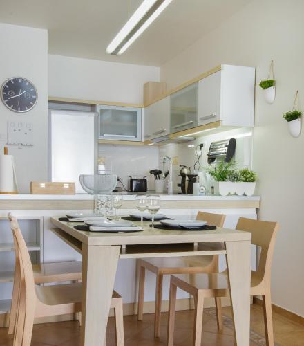 a kitchen with a table and chairs and a kitchen with white cabinets at Apartment Stefan in Sveti Stefan