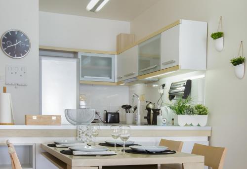 a kitchen with a table and a clock on the wall at Apartment Stefan in Sveti Stefan