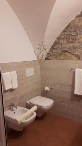 La salle de bains est pourvue de toilettes blanches et d'un lavabo. dans l'établissement La casina negli orti, à Arcola