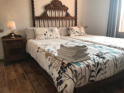 a bed with a pile of towels on top of it at Ca s’Hereu in Cala Millor