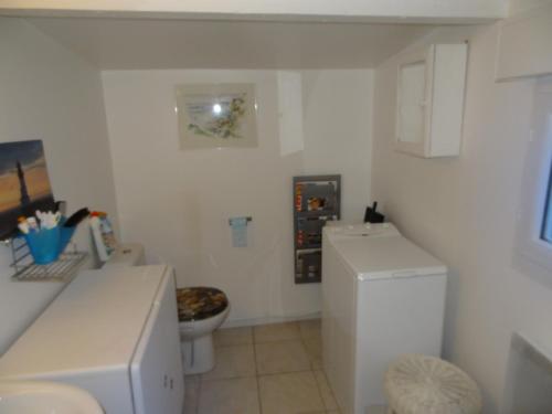 une salle de bain blanche avec toilettes et réfrigérateur dans l'établissement La Bethencouroise, à Béthencourt-sur-Mer