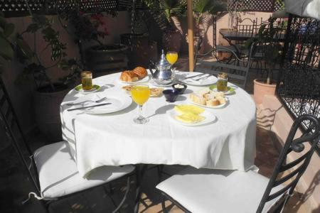 un tavolo bianco con piatti di cibo e bevande di Riad Linda a Marrakech