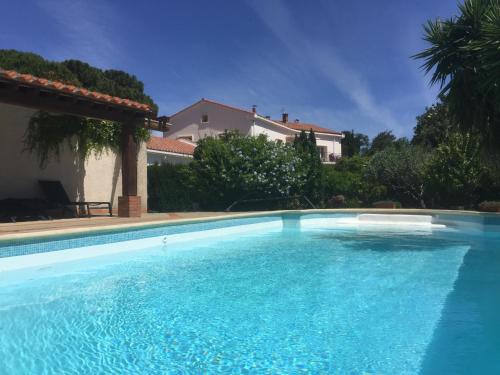 a large blue swimming pool in front of a house at Le Clos Saint André in Banyuls-sur-Mer