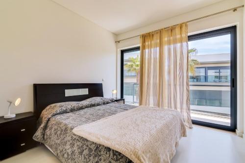 クアルテイラにあるCavalo Preto Beach Resortのベッドルーム1室(ベッド1台、大きな窓付)